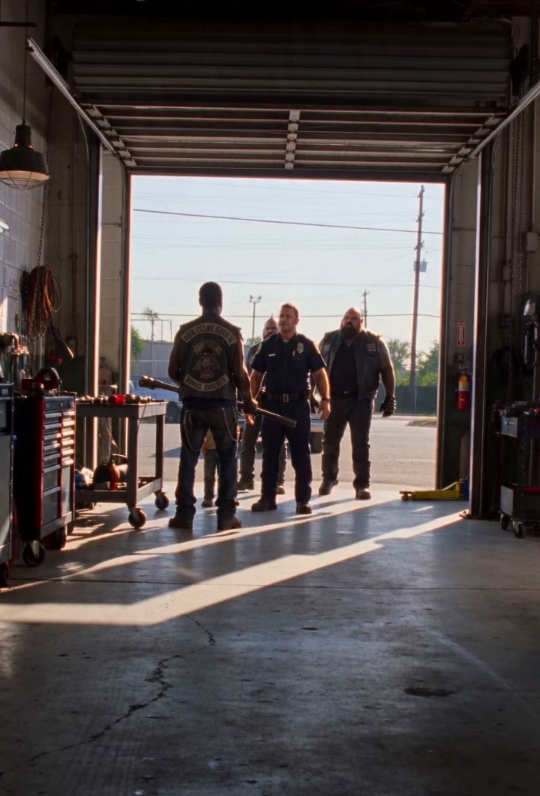 A smiling cop tries to drag a crying out of a repair shop — until one missing license plate stops him cold.