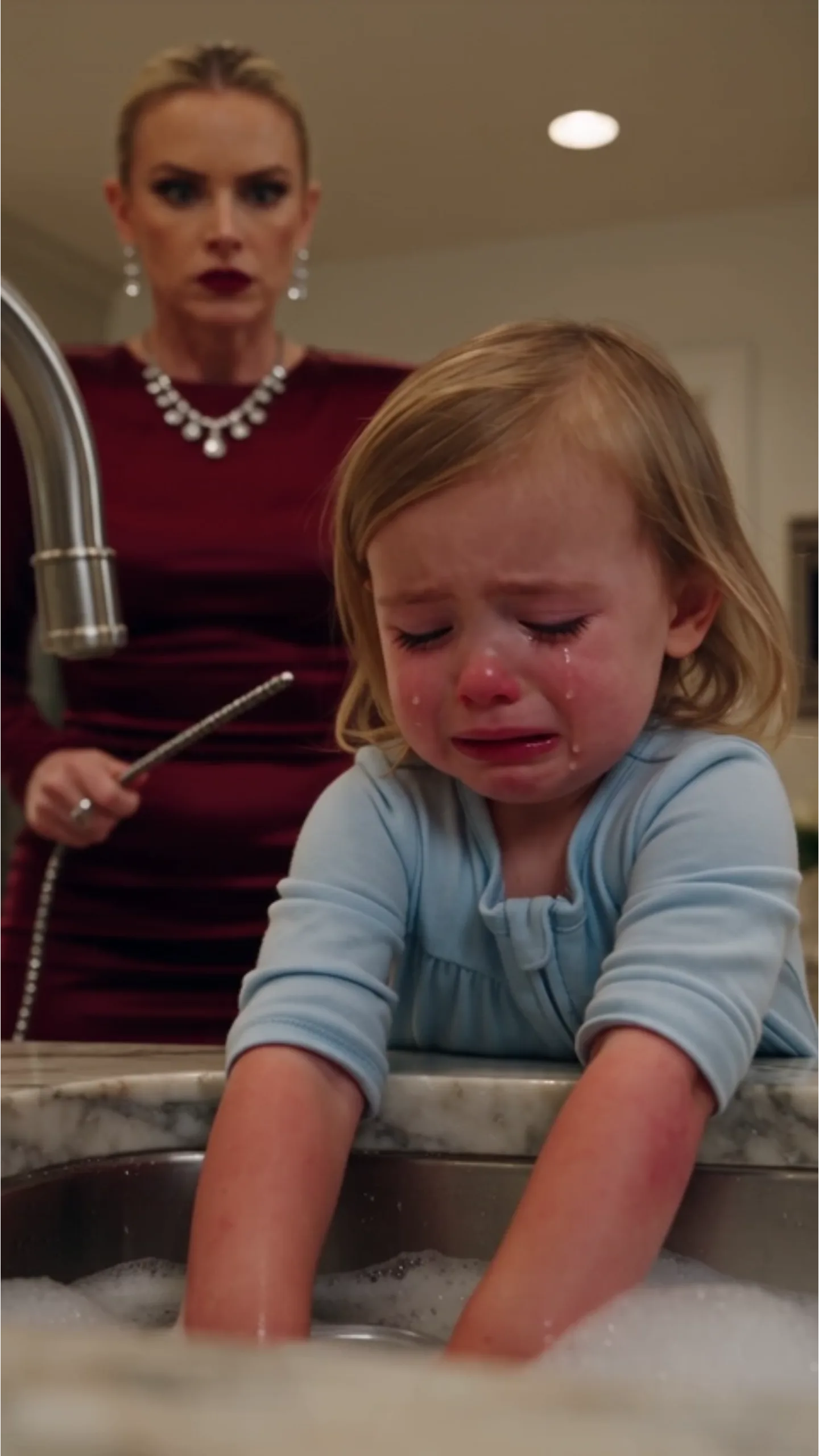 The silver picture frame shattered into a hundred jagged pieces across the hardwood floor, but no one in the room moved to pick up the glass. Little Sophie’s trembling body pressed so hard against Mark’s chest that he could feel the frantic, rabbit-fast thumping of her tiny heart through his suit jacket. Her small fingernails dug into his collar, white-knuckled, tears streaking through the light dust on her cheeks.