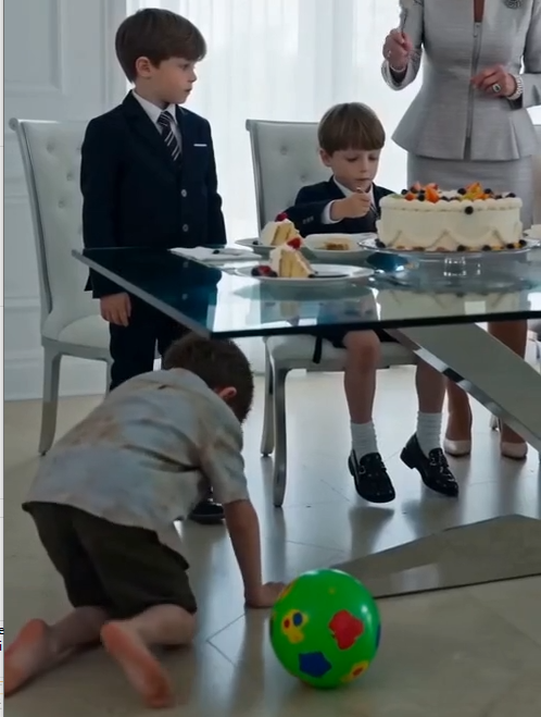 Victoria lifted another forkful of cake toward Liam, then pointed at my four-year-old son crawling barefoot beneath the glass table.