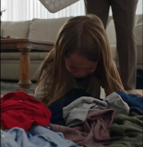 Bernice forcefully shoved the overloaded laundry basket back into Iris’s arms. The heavy basket knocked the little girl off balance, she fell onto her knees, clothes spilled across the floor, and she began crying while struggling to lift it again.