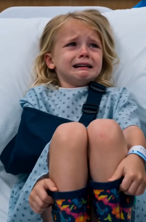 The Stepfather violently grabs Darby by one rain-booted ankle and yanks her toward the edge of the hospital gurney.