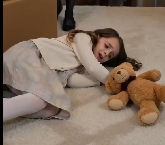 "Donatella violently shoves Elodie away from her bedroom doorway. Elodie falls onto the carpet beside stacked boxes while Rocco’s belongings are carried into the room.