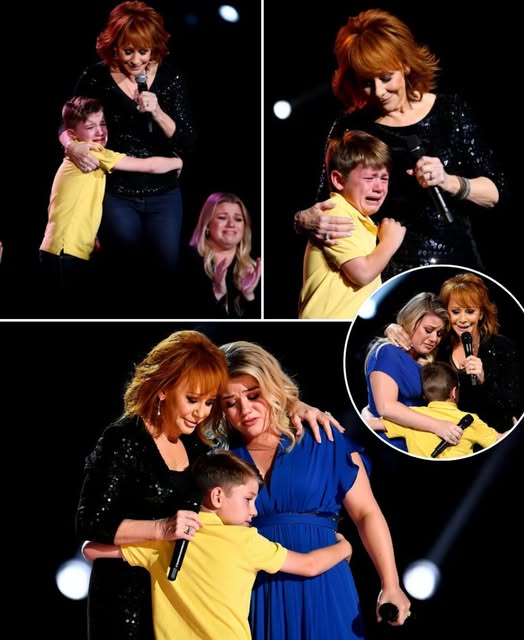 “You can do this, baby… I’m right here.” Reba’s voice trembled as she knelt beside 8-year-old Remy—Kelly Clarkson’s son—on the dimly lit stage. The music had stopped. The crowd held its breath. And in that stillness, tiny Remy clutched the mic with shaking hands. The song? Because of You. His mother’s heartbreak. His mother’s anthem. His first words were a whisper. But Reba stayed with him—steady, calm, “Granny” in every sense. As his voice grew, something changed. It wasn’t just a boy singing—it was a bridge between generations, pain, and healing. Backstage, Kelly sobbed silently, hand to mouth. Her little boy was rewriting her story in real time. And when that final note rang out, the crowd rose. But the real moment… was already over. And it belonged to them.