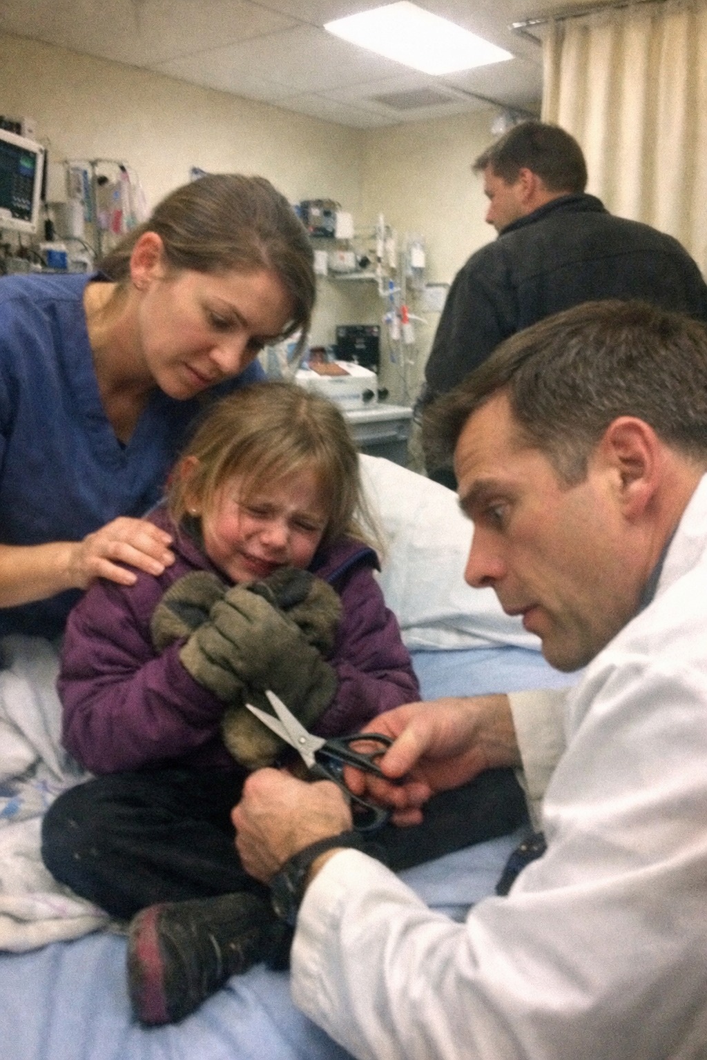 “Please… don’t take them off… he said the bad will come out…” — The terrified whisper of a seven-year-old girl in the ER made my hands freeze mid-motion,