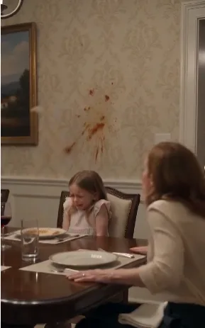 Claire walked toward the door carrying her daughter while Daniel stayed at the table beside his mother.