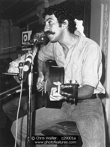 Jim Croce singing into a microphone with acoustic guitar