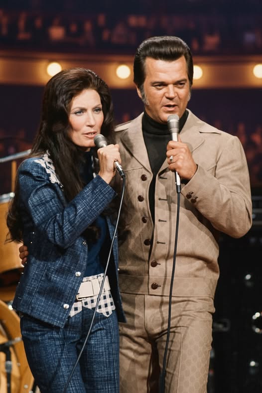 “Back Home Again,” as performed by Conway Twitty and Loretta Lynn, feels like a gentle country confession about the quiet miracle of returning