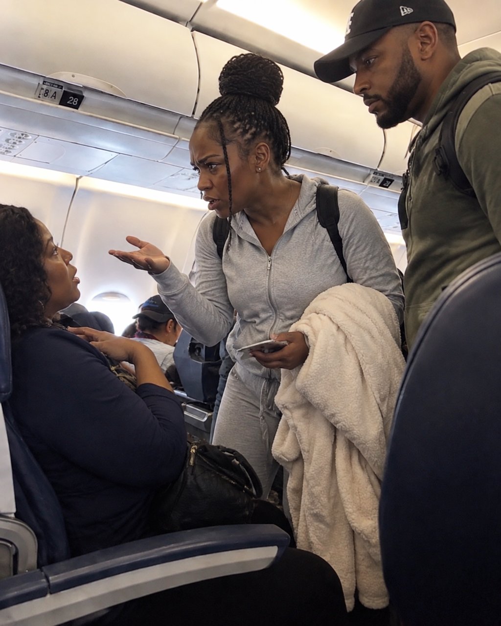 A woman took my reserved seat on a flight and refused to move — then my husband walked over and said, "What are you doing here?"