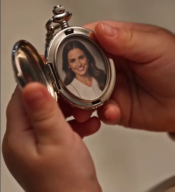 Eira quietly opens her late mother’s keepsake locket beside the engagement table.