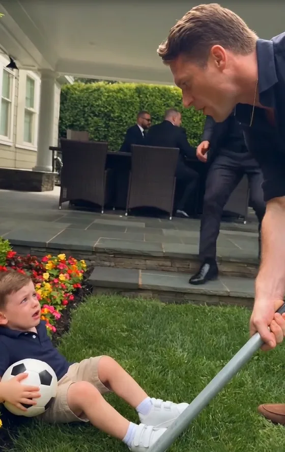 Three-year-old Eli Ravello bent beside the flower bed to retrieve his football.