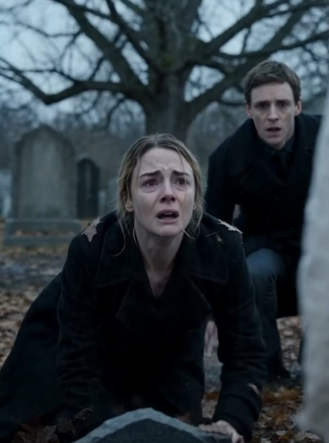 The mother was kneeling in the wet leaves, her black coat pressed against th